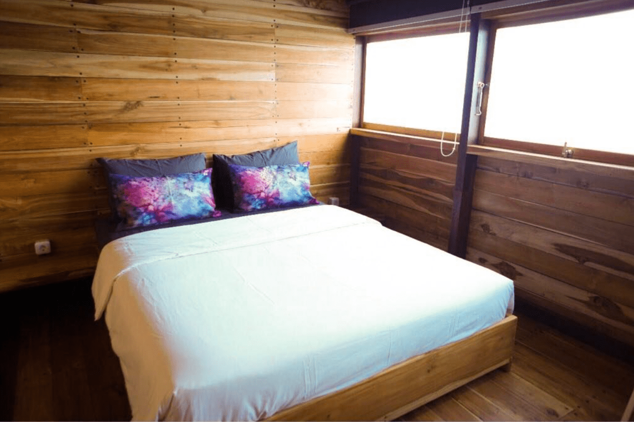 A bed in a room with wooden walls.