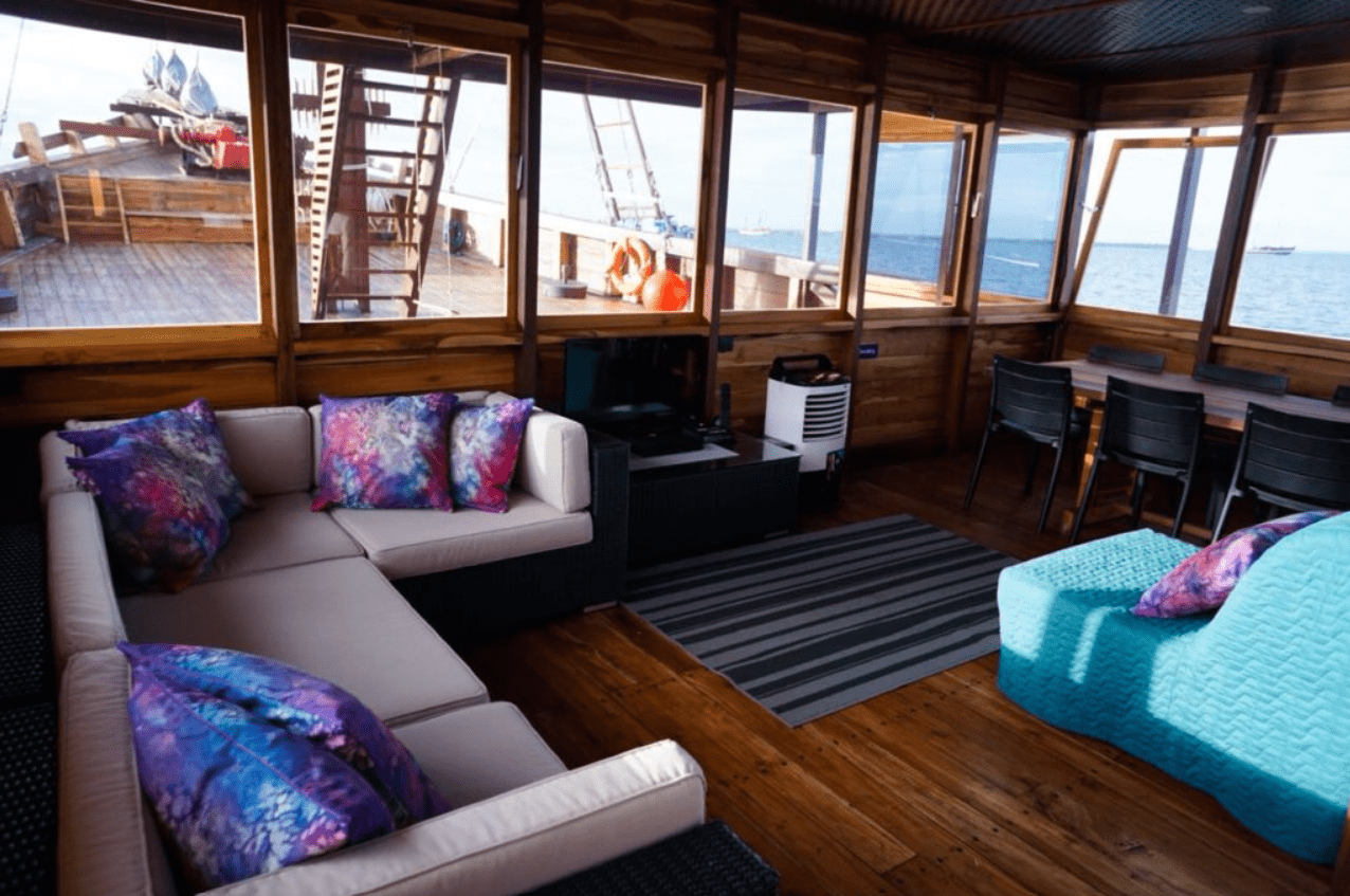 A living room on a boat with a view of the ocean.