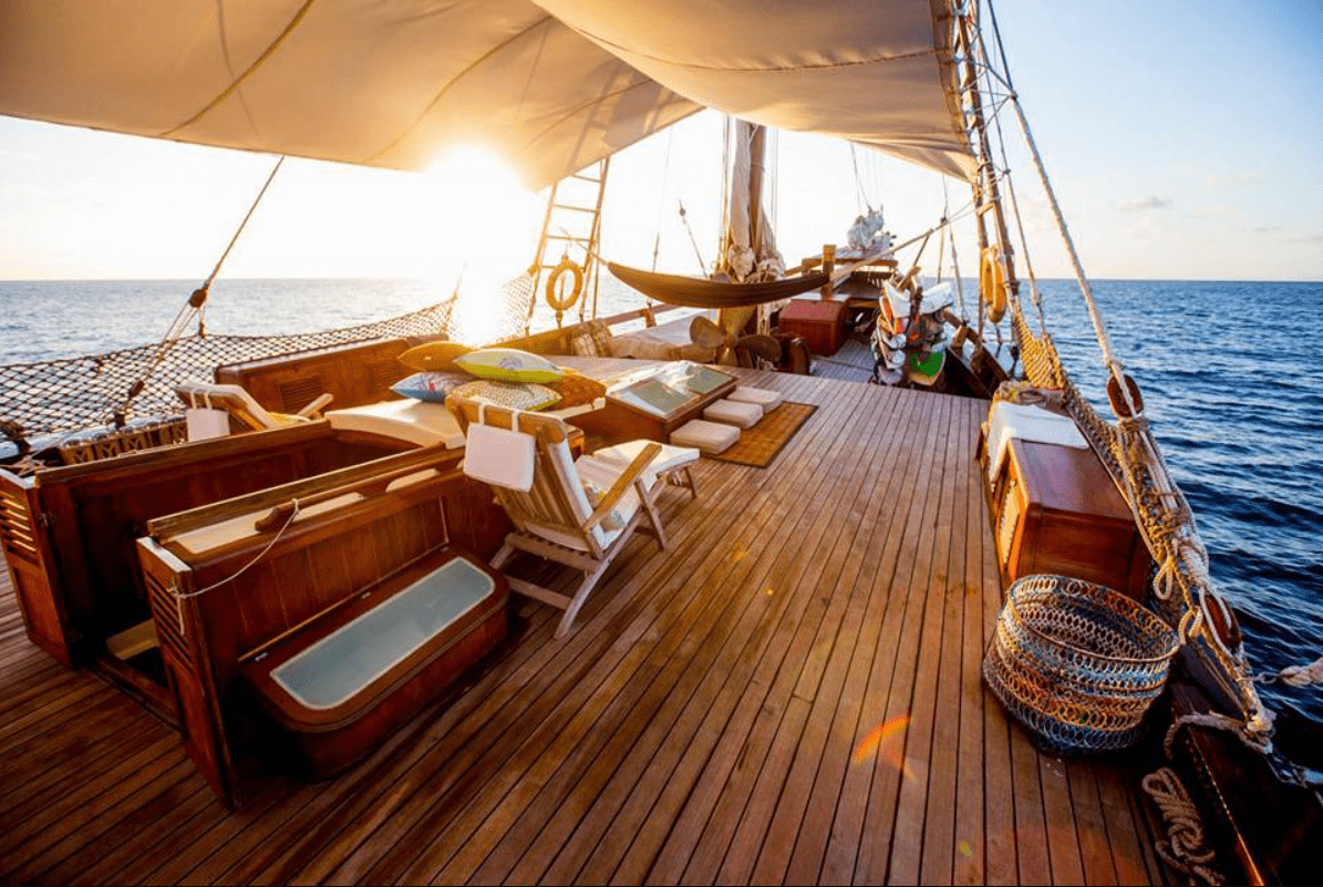 The deck of a sailing ship with wooden furniture.