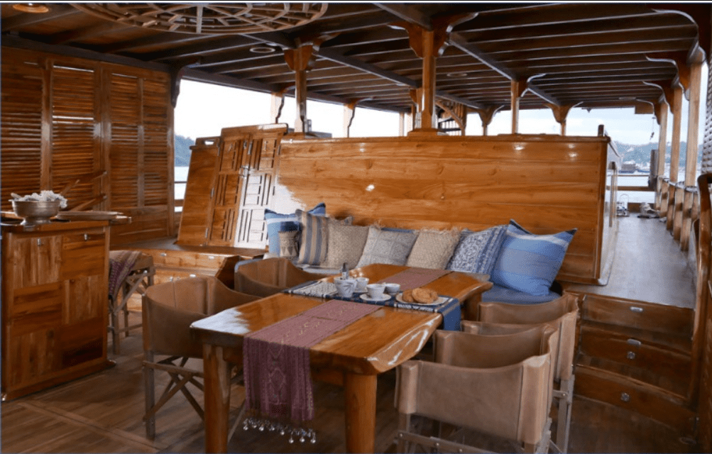 The interior of a wooden boat with a table and chairs.