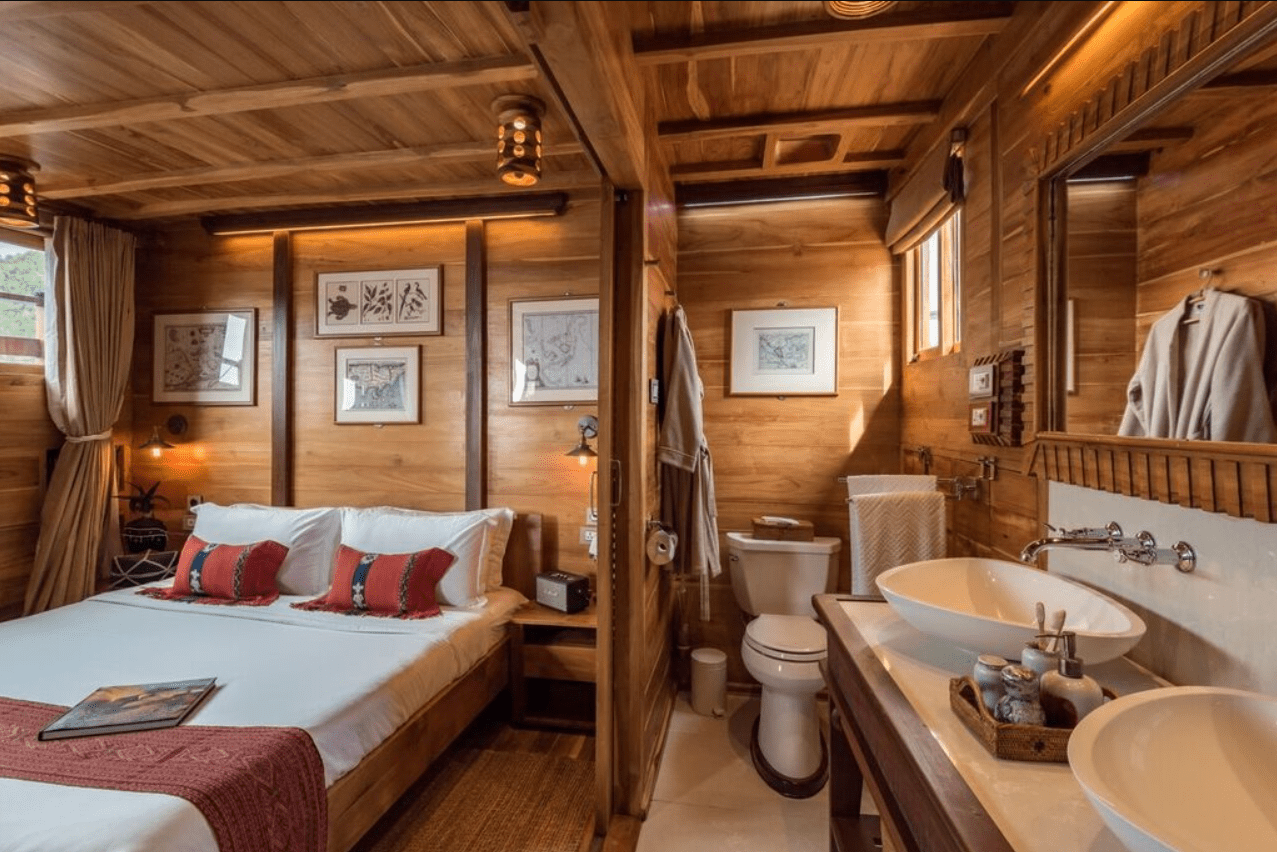 A wooden cabin with a bed and a sink.