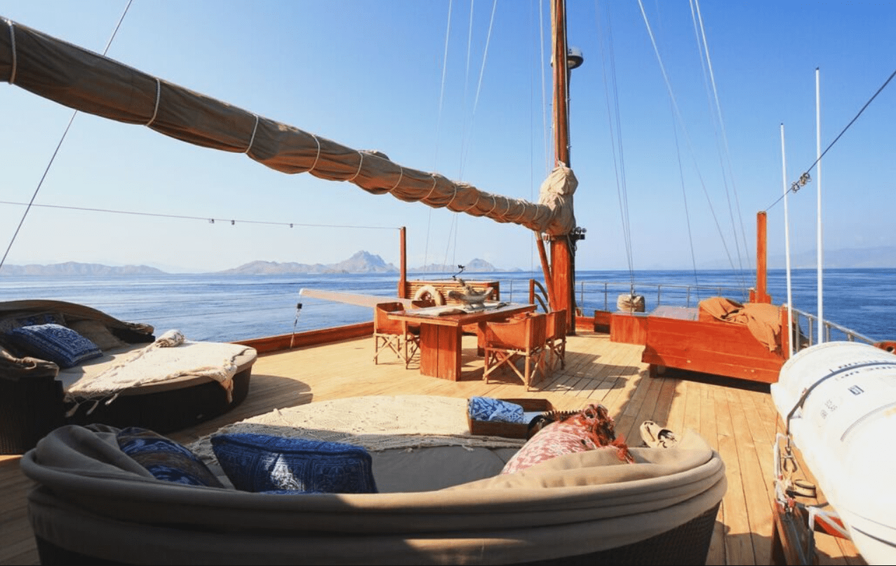 The deck of a sailboat with furniture on it.