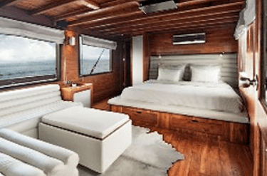 A cabin on a boat with a bed and couch.