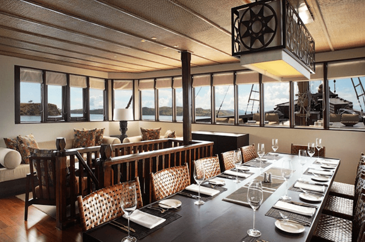 A dining room with a view of the ocean.