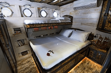 A room in a boat with a bed in it.