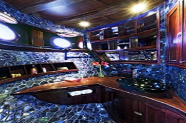A bathroom on a boat with blue tiled walls.