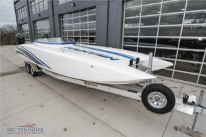 A 2018 Fountain 32 Thundercat speed boat parked in front of a garage.