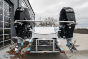 A 2018 Fountain 32 Thundercat boat with two motors parked in front of a building is available for sale.