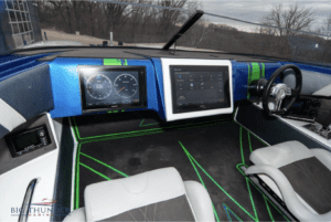 The interior of a 2018 boat with a blue and green dashboard.