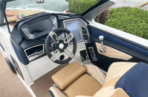 The interior of a 2023 MasterCraft X24 boat with a steering wheel and for sale.