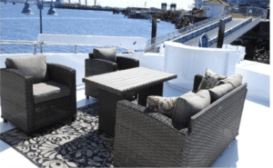 A Tarrab 112 wicker furniture set on a deck with a view of the water.