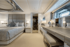 A bedroom on a luxury yacht (Oceanco 126) with a bed and a dresser.